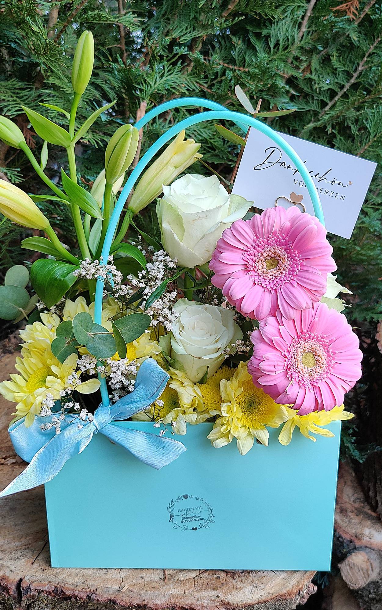 Hellblaue Blumentasche mit rosa Gerbera, weißen Rosen, Lilien und Chrysanthemen